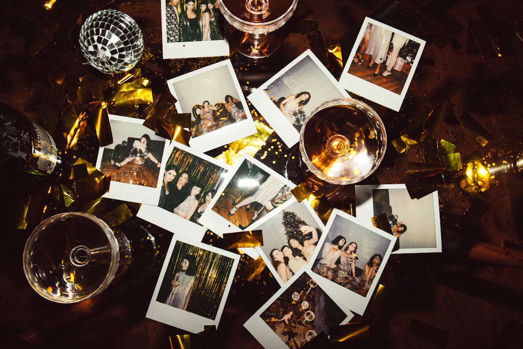 Bastinews.xyz A collection of polaroid photos and glasses on a festive table, capturing party memories.