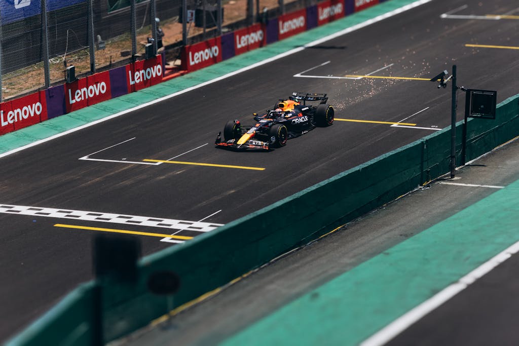 i square – Lenovo Ex A Formula 1 car speeds down the track during a race, showcasing high performance.