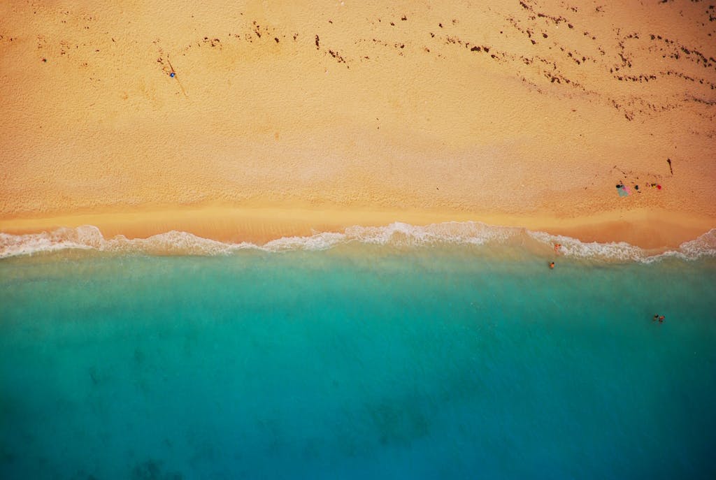 Pappedeckel A stunning aerial shot of a sandy beach meeting turquoise waters, perfect for travel inspiration.