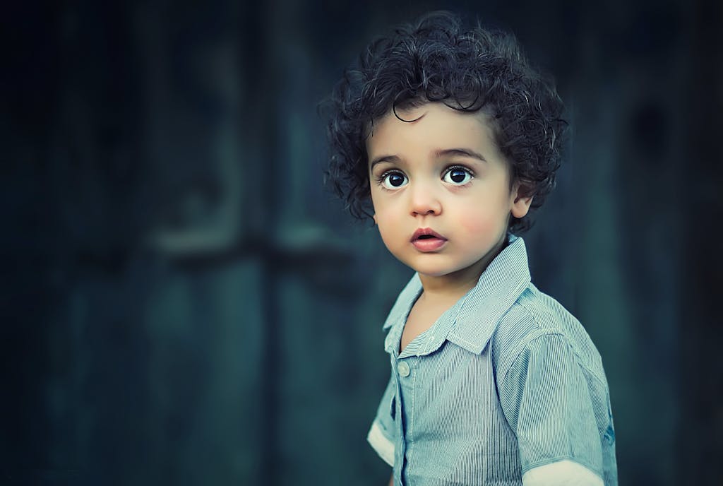 VirtusPlays Charming portrait of a young boy with curly hair and striking eyes.