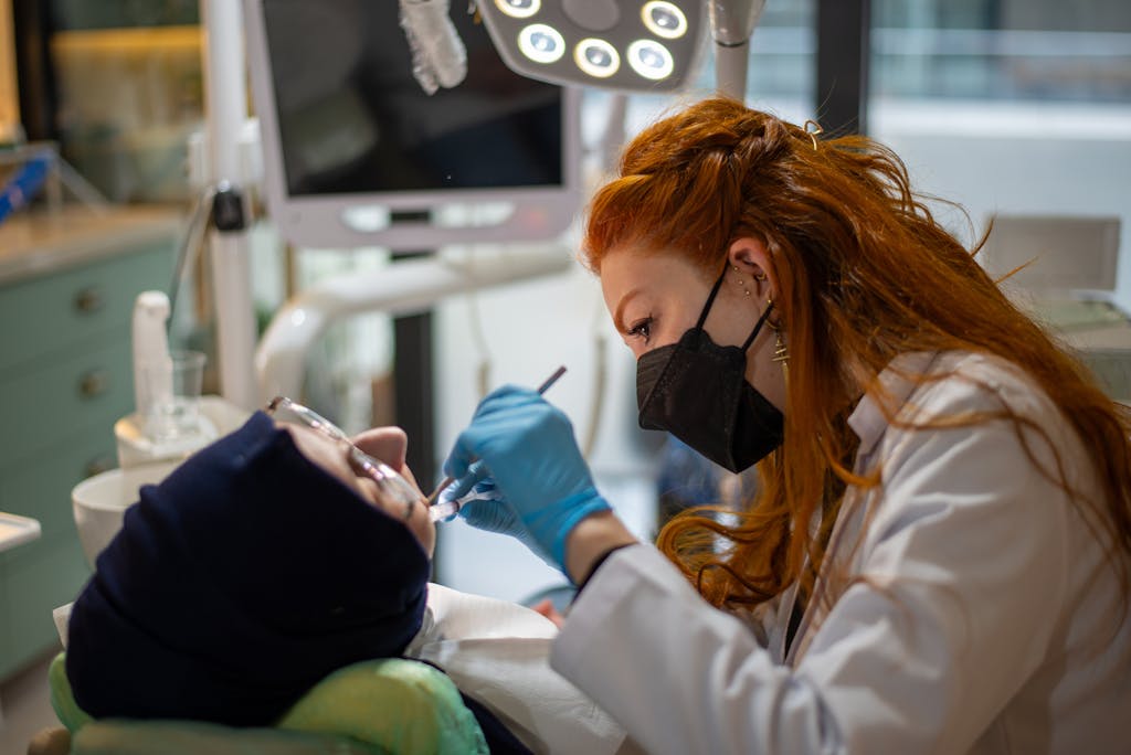 Dental Software News Today A female dentist focused on treating a patient in a modern, well-equipped dental clinic.