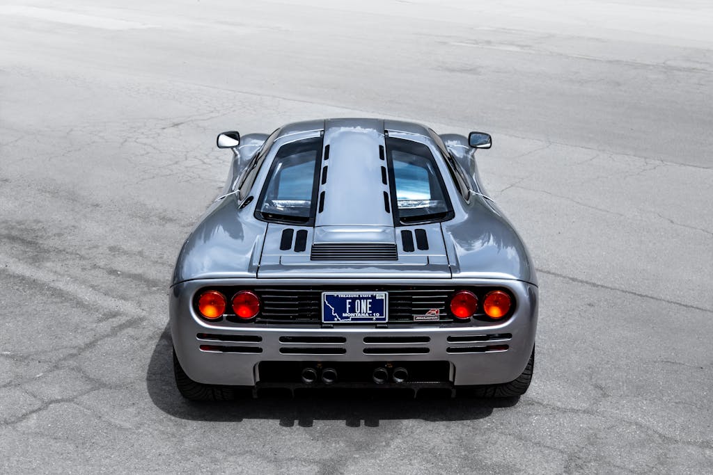 MC Lyte Car Crash A sleek McLaren supercar captured from the rear on an open road, highlighting its design and elegance.