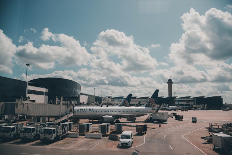 United Flight UA109 Diversion A United airplane parked on the airport apron under a scenic cloudy sky.