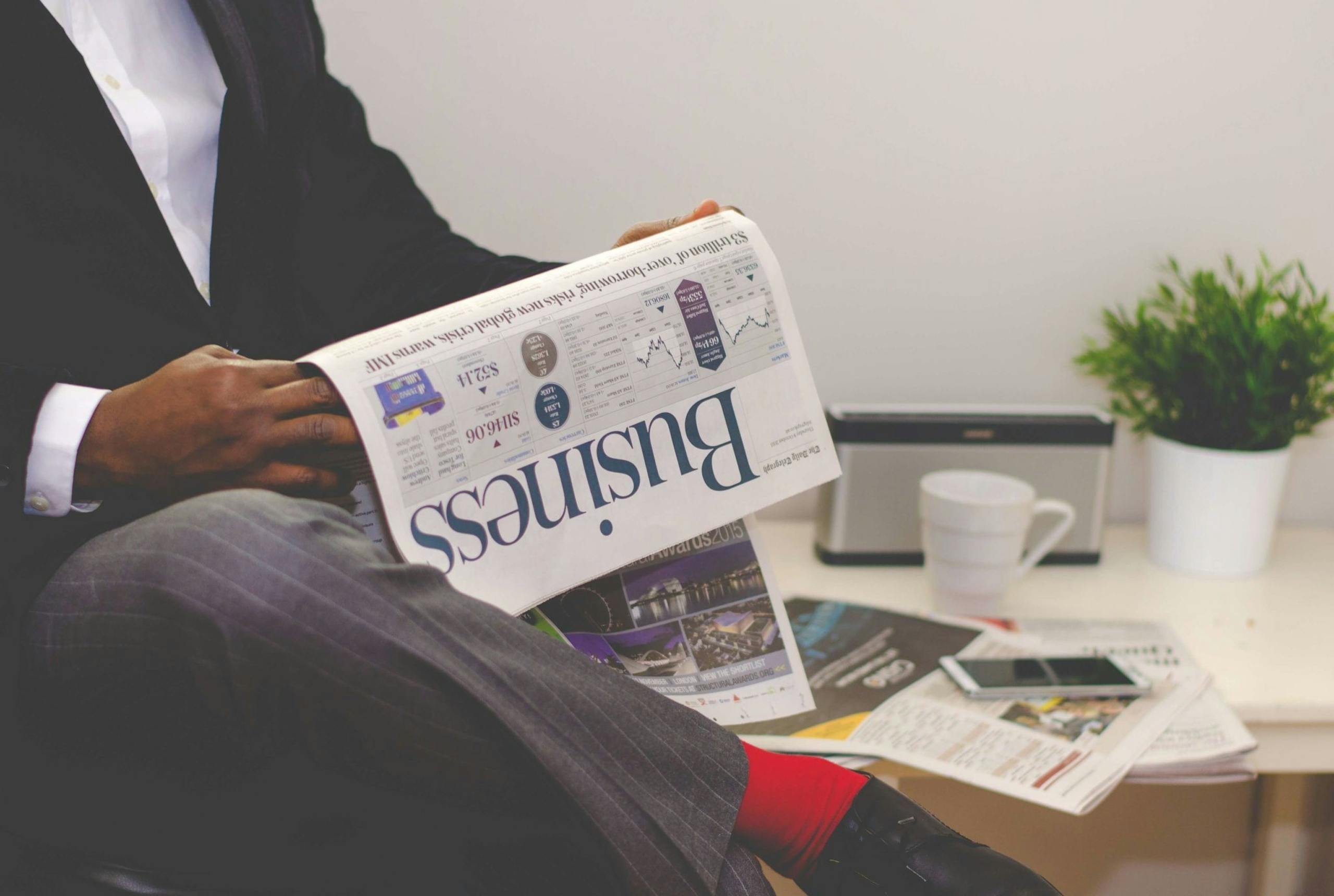 theglobeandmail.com.mx Businessman reading a financial newspaper at a desk, highlighting finance and commerce theme.