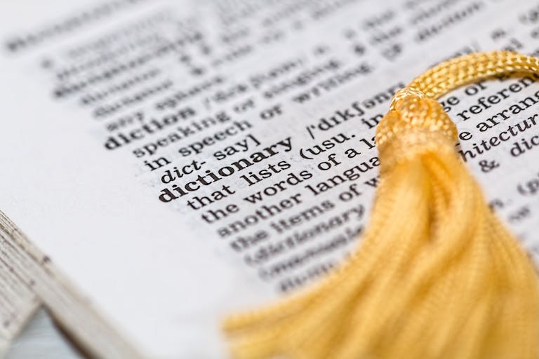 Bottlecrunch Close-up image of a dictionary page focused on the word 'dictionary' with a yellow tassel.