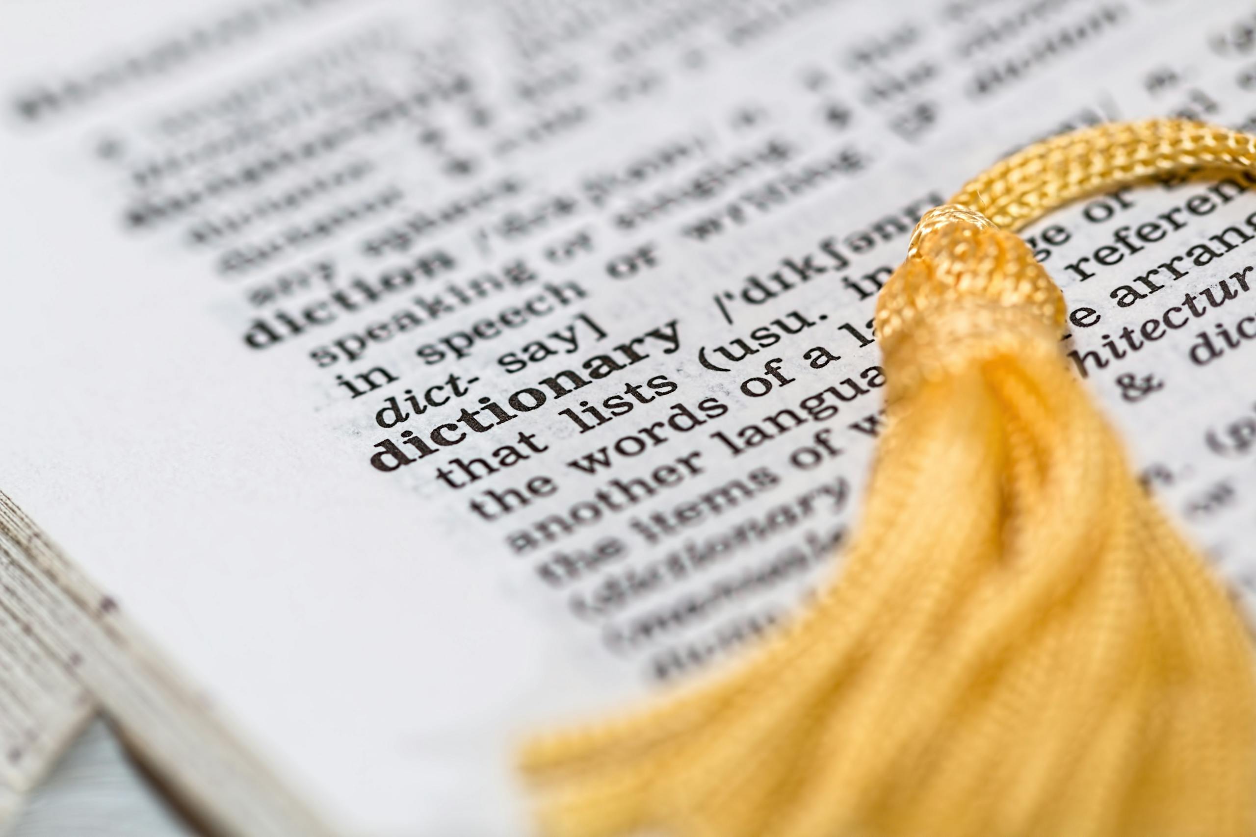 Bottlecrunch Close-up image of a dictionary page focused on the word 'dictionary' with a yellow tassel.
