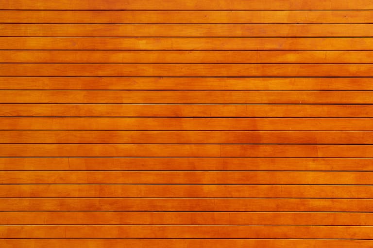Voozon Close-up of a vibrant orange wooden wall texture, ideal for backgrounds.