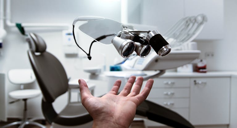 Dental Software News Today Floating dental loupes in a modern, clean dentist office setting.