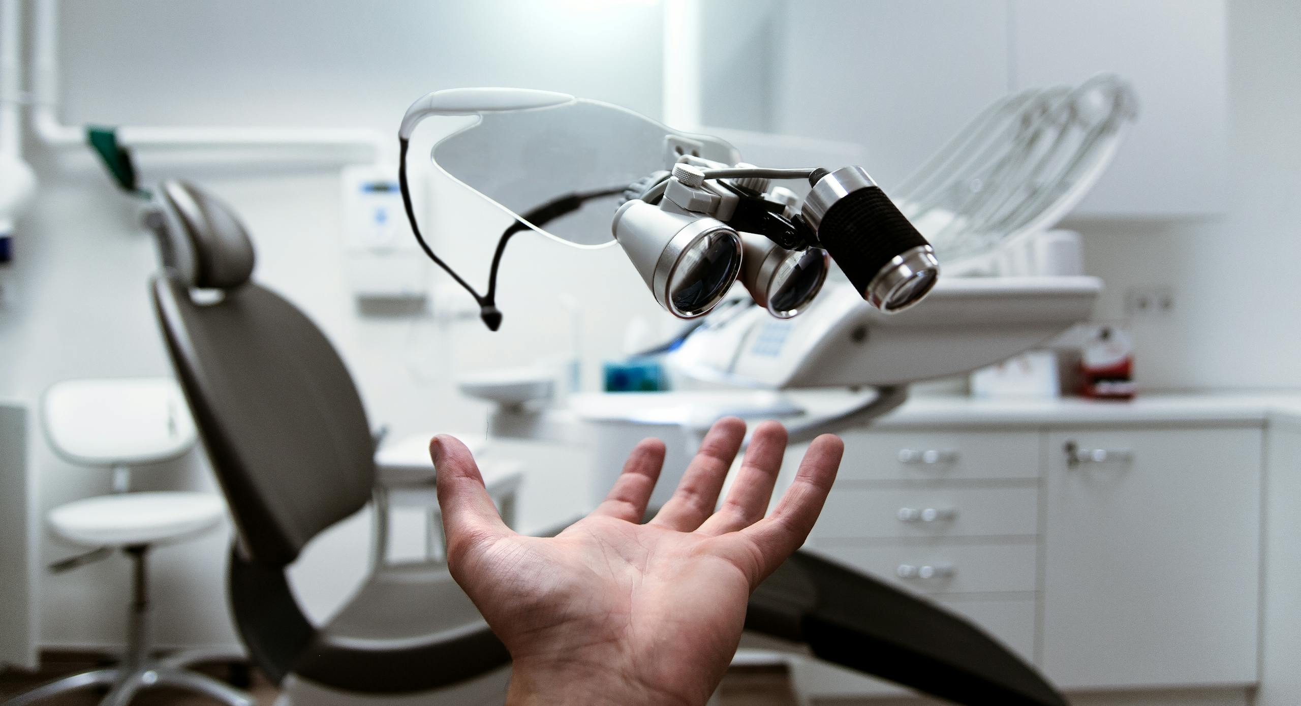 Dental Software News Today Floating dental loupes in a modern, clean dentist office setting.