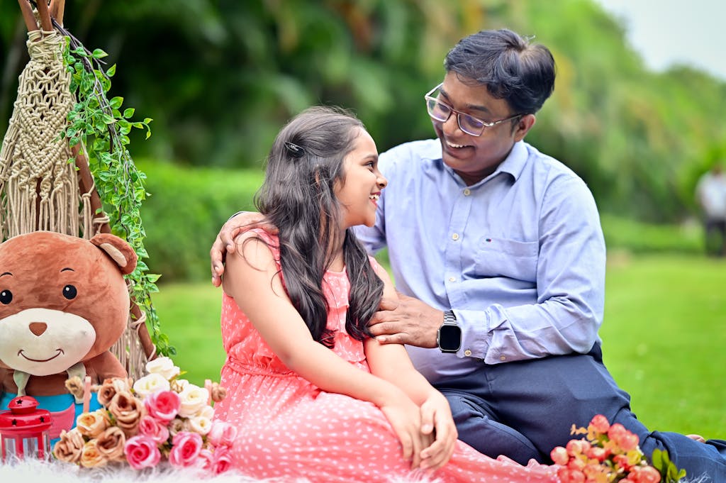 Bolly4u MeHappy father and daughter bonding during a cheerful outdoor picnic in a garden.
