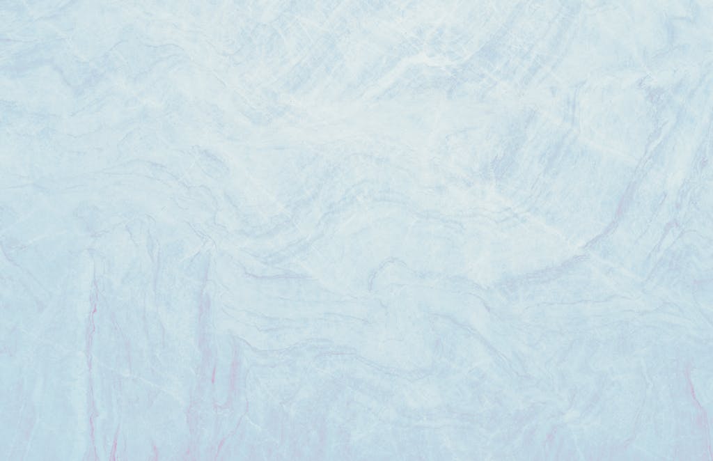Emfyteymata  Light pastel blue marble texture showcasing smooth surface with soft wave patterns, ideal for design use.