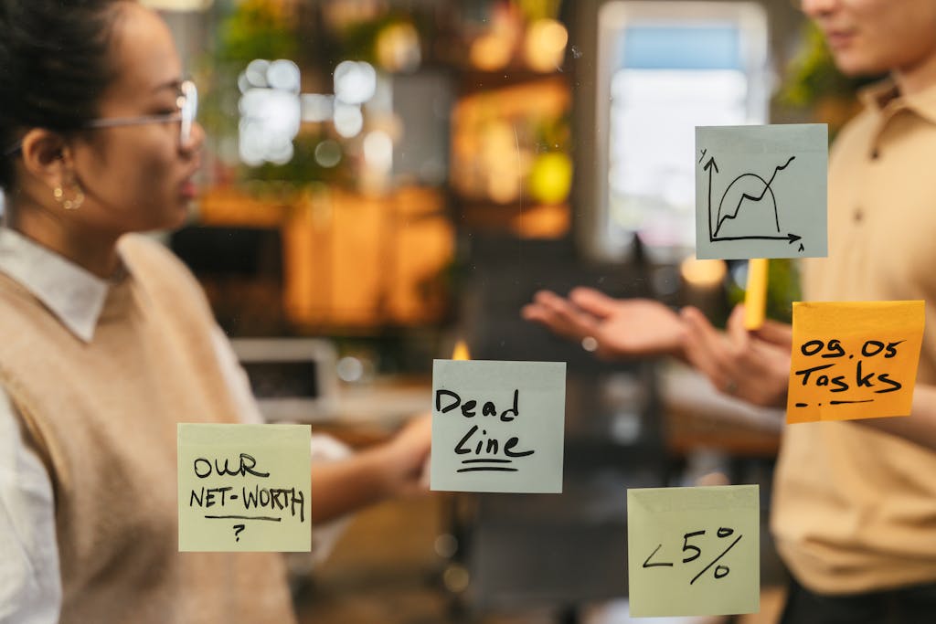 Damon Darling Net Worth Office meeting with sticky notes on a glass wall showing discussions and brainstorming.